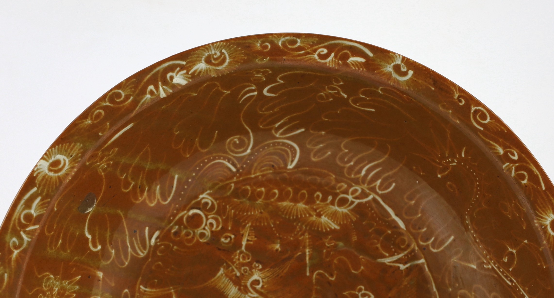 A Chinese Swatow slip-decorated brown ground dish, Zhangzhou kilns, early 17th century, 37cm diameter